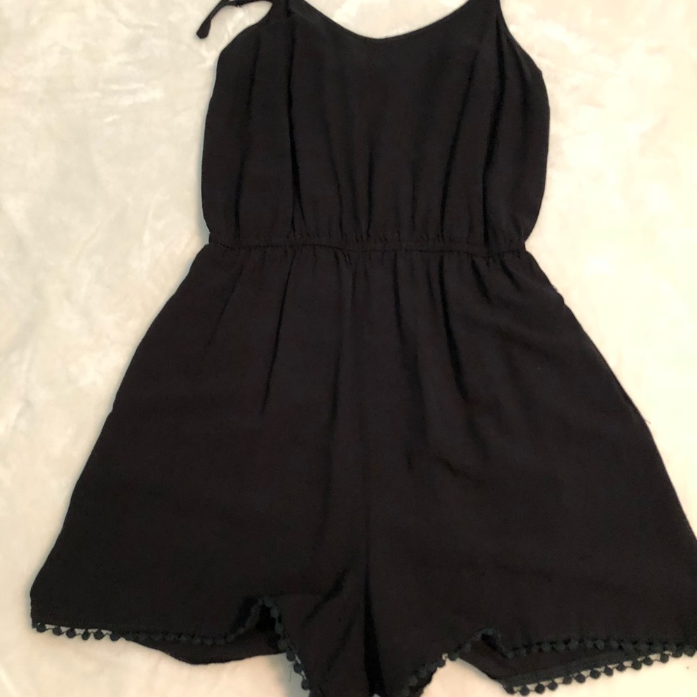 Black romper with fringe at the bottom.